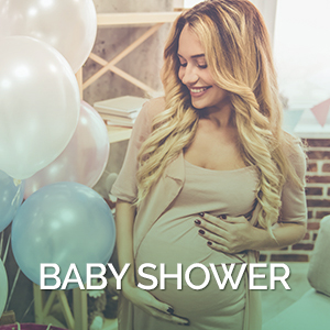 Celebrating baby shower Beautiful pregnant woman is smoothing her tummy and smiling during baby shower